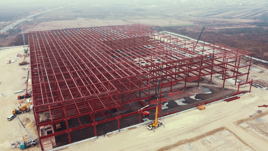 Warehouse Construction from metal structure. Industrial building on light gauge steel framing. Frame of modern hangar or factory. Construction site with steel structure warehouse. Top view on a roof Royalty-Free Stock Footage #1085521280
