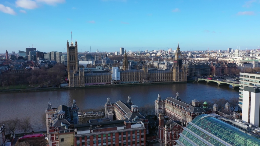 Aerial drone video of iconic City of Westminster with houses of Parliament, Big Ben and Westminster Abbey in front of river Thames, London, United Kingdom