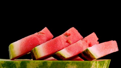Juicy natural watermelon on a black background, sliced ​​red watermelon.