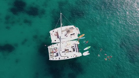 Phuket, Thailand, 19, December, 2019:
Two sailing catamarans together, tourists swim in the clear sea during a boat trip, view from above