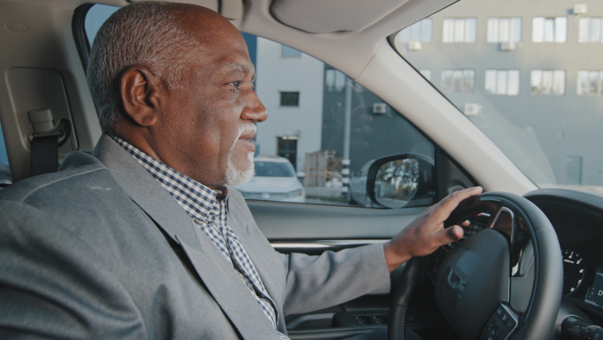 Elderly african american businessman driving automobile on roadway experienced confident driver carefully looks at road journey traveling mature man buys car takes test drive enjoy comfortable ride