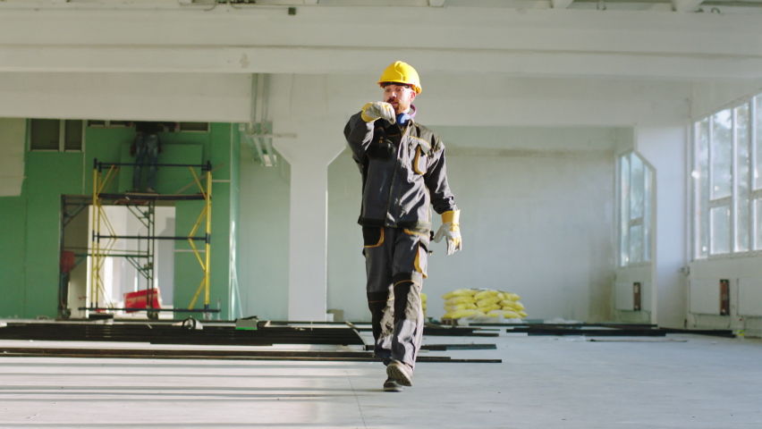 Charismatic and good dancing engineer man at construction site at the end of the day he wearing protective helmet and uniform. 4k Royalty-Free Stock Footage #1085526599
