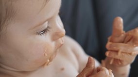 Video with a little baby girl eating her dinner and making a mess. Baby eating mess, great design for any purposes. Head shot.