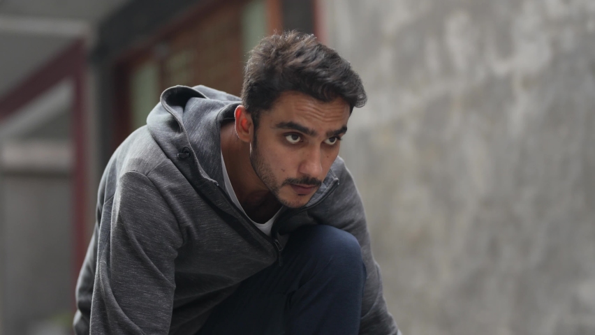 Asian Handsome athletic man in sportswear starting a race for running on street. Active bearded male spending free time for regular training on fresh air outdoor. Man is Concentrate and breath.