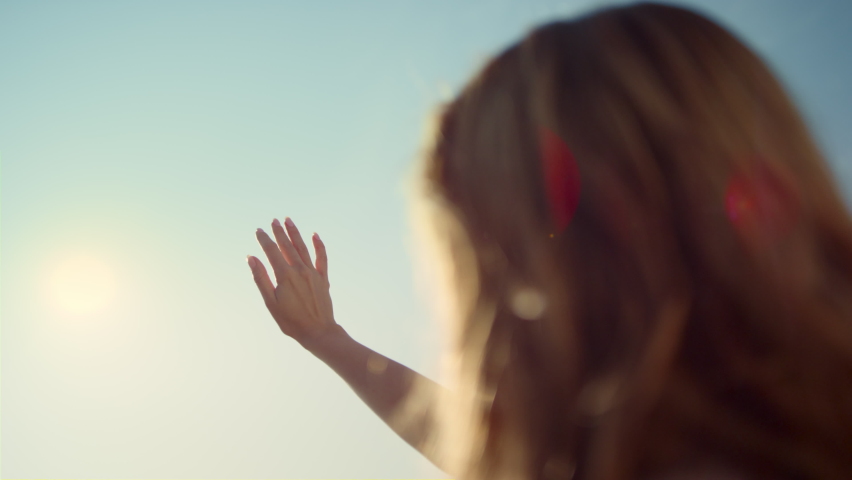 Closeup woman hand moving fingers on sunshine background. Closeup sunbeam through woman fingers. Unrecognizable woman playing sunlight with hand. View of woman back with hand touching sunshine outside Royalty-Free Stock Footage #1085534198