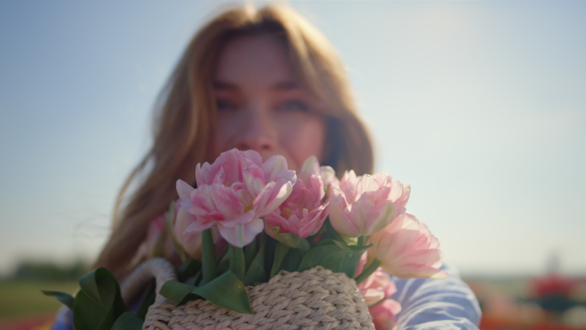 Portrait of beautiful woman smelling gentle pink flowers in sun reflection. Closeup smiling lady face with fresh spring flower bouquet in sunlight. Face of blue-eyed happy girl enjoying flower buds. | Shutterstock HD Video #1085534384