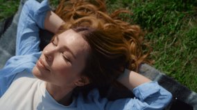 Closeup happy girl lying on green grass. Beautiful woman enjoying sunny summer in park outdoors. Relaxed young lady in blue shirt smiling to sun in spring meadow. Pretty female person on plaid outdoor - Powered by Shutterstock - Get 15% off with code: PIKWIZARD15