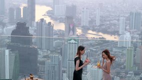 Beautiful Asian woman friends meeting and drinking cocktail together at skyscraper rooftop restaurant in metropolis at summer sunset. Female friend enjoy outdoor lifestyle activity in the city at nigh - Powered by Shutterstock - Get 15% off with code: PIKWIZARD15