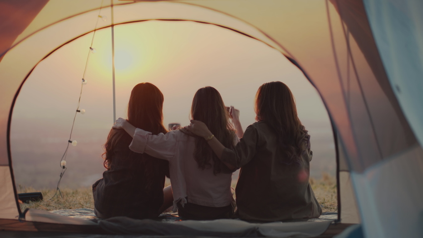 Friendship group of Asian young women having fun and enjoy Sit together, cuddle, drinking coffee, and watch the sunset. outdoor camping trip in nature, Females Lifestyle Vacations Relaxation. Royalty-Free Stock Footage #1085550047
