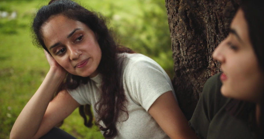 A young Indian female reacting to her friend