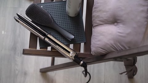 Electric hair curling iron for hairdresser. Comb, doing hair with professional hairbrush. Do curls with curler, volume hairdo.
