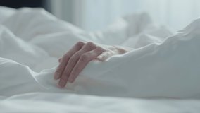 Close Up Shot of a Caucasian Woman Hand Caressing the Sheets, While The Sun Shines Through the Window in The Background. - Powered by Shutterstock - Get 15% off with code: PIKWIZARD15