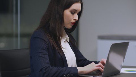 Sexual misconduct at office. Young attractive woman typing on laptop suffering from her boss harassment, unrecognizable lustful man touching female hair, slow motion