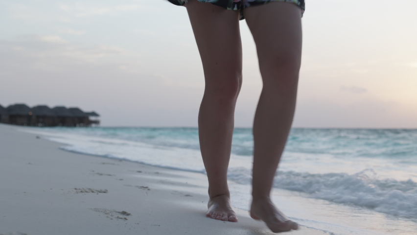 Slow motion of woman feet walking barefoot on the white sand beach at sunset. Female tourist on summer vacation in Maldives. | Shutterstock HD Video #1085569271