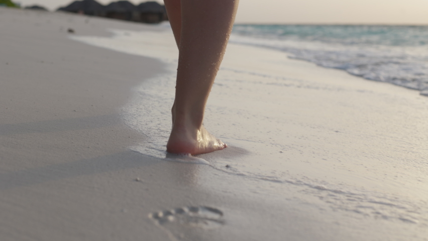 Slow motion of woman feet walking barefoot on the white sand beach at sunset. Female tourist on summer vacation in Maldives. | Shutterstock HD Video #1085569274