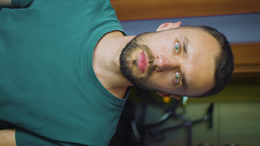 vertical portrait of man putting hand on heart. young caucasian male shows concept of love and support looking at camera