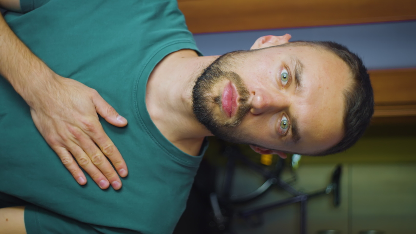 vertical portrait of man putting hand on heart. young caucasian male shows concept of love and support looking at camera