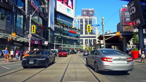 Toronto, Ontario, Canada - August 5th, 2019. Driver Point of View Driving Through Downtown City During Day. Drive Car Vehicle Along Street Tall Buildings and Pedestrians Transportation Travel.