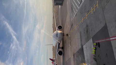 NEW YORK, USA - OCTOBER, 25, 2021: Vertical video. Airplane arriving at JFK airport terminal. Aeroflot aircraft. Ladder, boarding passengers, loading luggage.