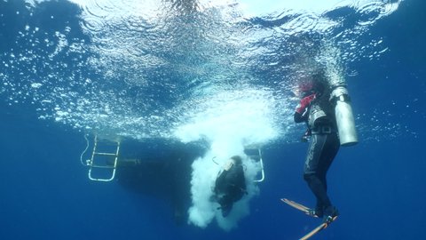 boat underwater scuba diver jumps into water ocean scenery