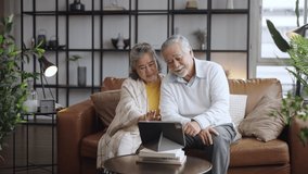 Asian mature senior couple look talk to laptop tablet camera at home. video calling communicate in online chat - Powered by Shutterstock - Get 15% off with code: PIKWIZARD15