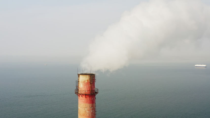 Aerial video on the chimney of an old thermal power plant from which white smoke comes out. Carbon emissions concept. Reduce CO2 emissions. Paris Agreement. Developing countries | Shutterstock HD Video #1085595233