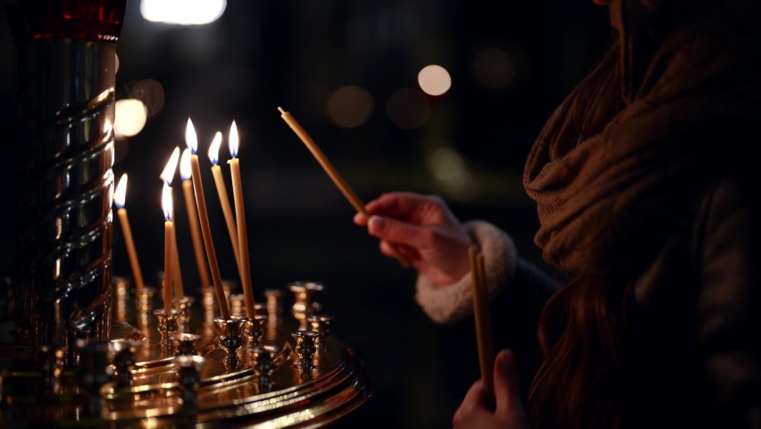 woman in orthodox church, burning candle and praying, parishioner inside temple Royalty-Free Stock Footage #1085596661
