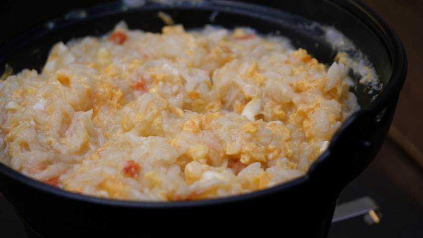 Close-up video of crab porridge. A dish in which crab meat and eggs are topped in a hot pot soup.