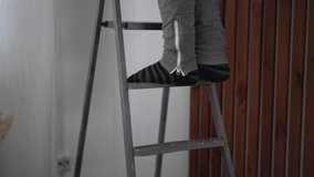 Close-up of man climbing down ladder at home Video 4k