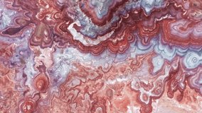 Top down aerial view red, pink and blue painted desert surface like water waves, beautiful natural background with text space. Bright, vibrant colorful landscape footage. Drought, global warming shot