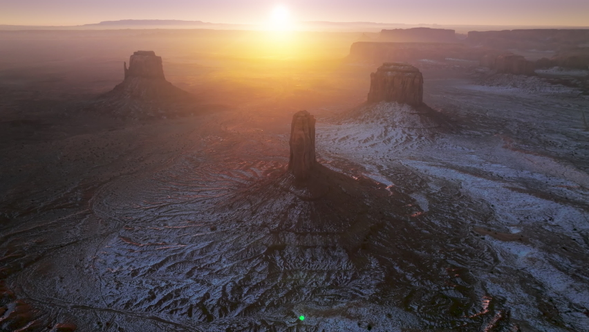 Beautiful sunrise over wild red rocks mountains in winter morning in Monument Valley, Utah Arizona, southwest USA. Wilderness nature aerial drone footage 4K with copy space background
