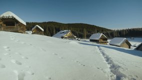steady smooth video with forwarding movent in a small mountains village covered in snow at wintertime captured in Slovenia in Pokljuka forest in village Zajavornik with nice light