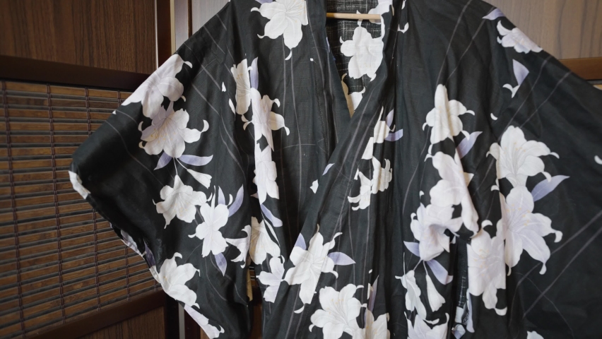 Black And White Floral Kimono Hung Inside Foldable Wooden Room Divider. Traditional Japanese Garment. zoom-out