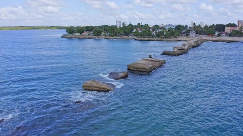 Aerial view of outstanding rocky jetty at beach of Malecon SAN PEDRO DE MACORIS during cloudy day,Dominican Republic