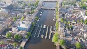 Inscription on video. Amsterdam, Netherlands. Flying over the city rooftops. Amstel River, Amstel Gateways. Heat burns text, Aerial View