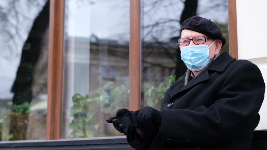 An old grandfather in a protective mask is sick with the new Omicron virus. 