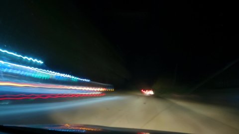 4K Hyper lapse of the Indian highway at night as seen from inside the car  with dirty windshield . POV from inside the car. Cars leaving light trails.  High speed motion of the car at Night