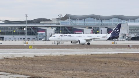 Kyiv, Ukraine - 16 JAN 2022: Airbus 321 of the Lufthansa company rides on the taxiway at Boryspil International Airport. Snowless winter, cloudy, windy.