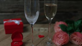 romantic atmosphere love background: celebration of valentines day holiday or date anniversary or proposal evening. two glasses champaign, diamond engagement ring, red gift box, bunch of pink roses  - Powered by Shutterstock - Get 15% off with code: PIKWIZARD15