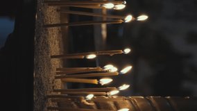 Burning Yellow Candles in Sconces During Church Service. Faith, Spirituality and Religion Concept. Vertical Video