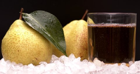 Yellow pear juice in cold ice with fresh and yummy pears, natural and organic fruits in grey background. Filmed high speed cinema camera, slow motion footage, 8K downscale, 4K.
