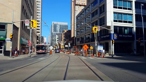 Toronto, Ontario, Canada - August 5th, 2019. Driver Point of View Entering and Driving Through Construction Zone Downtown City During Day. Drive Car Vehicle Enter Street Tall Buildings and Pedestrians