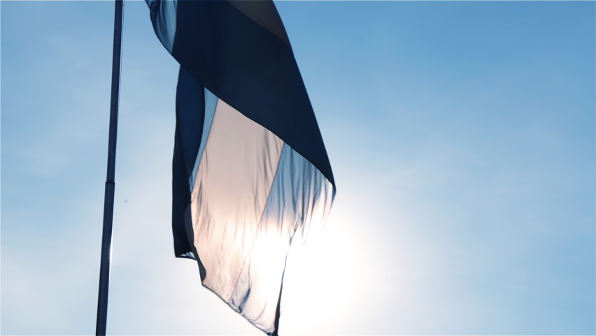 Flag of Argentina on a Flagpole Against a Blue Sky and Sun in San Martin Square (Plaza General San Martin) in Retiro, Buenos Aires, Argentina. 4K Resolution. Royalty-Free Stock Footage #1085640713
