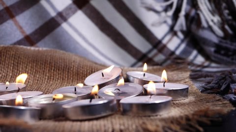 Tealight candles arranged for meditation on warm background medium slow motion shot selective focus