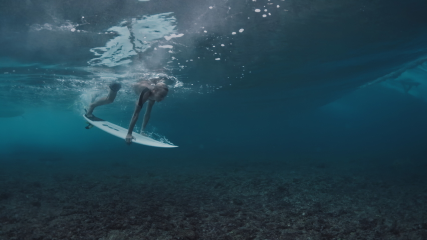Surfing in Maldives. Teen boy dives with surf board underwater to pass the ocean wave | Shutterstock HD Video #1085644532