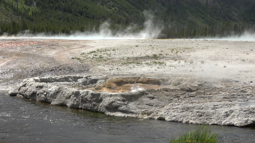 Firehole River Yellowstone bubbler geyser 4K. River flows through several ecological geyser basins in the park including the Upper Geyser Basin, which contains the world-famous geyser Old Faithful.