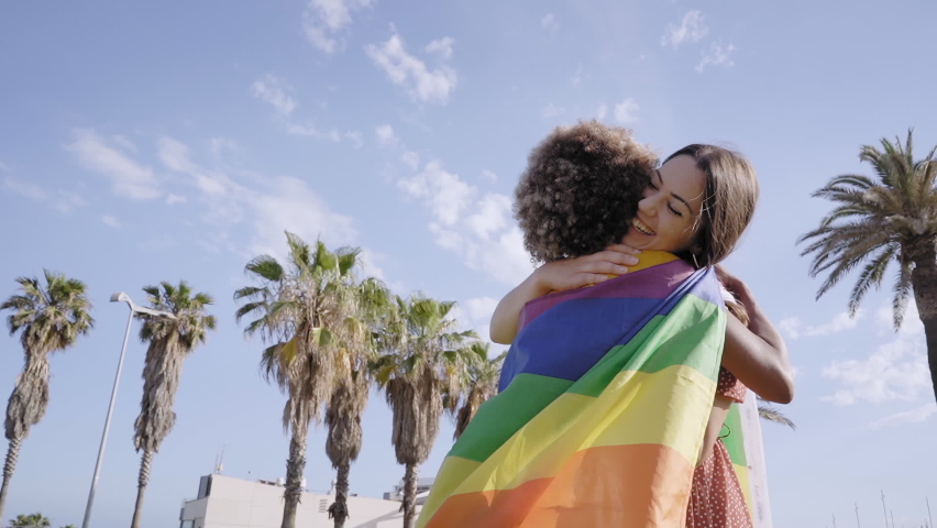 Lesbian loving couple hugging with rainbow flag. Concept of pride, homosexual, equality, freedom. Copy space. | Shutterstock HD Video #1085649200