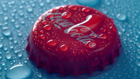 Tyumen, Russia-January 19, 2022: Coca Cola red cap of glass bottle. Droplets of water close up