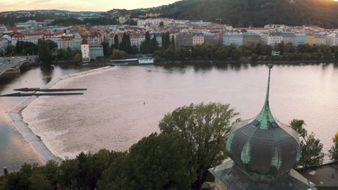 Aerial View Of River Vltava In Prague With Sunset Skies In Background. Pan Right Establishing Shot