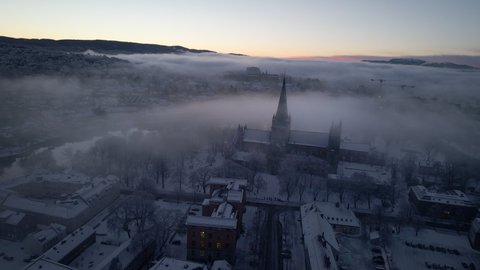 Nidaros Cathedral (Nidarosdomen) In Fog And Snow On A Winter Sunrise In Trondheim, Norway. aerial orbit